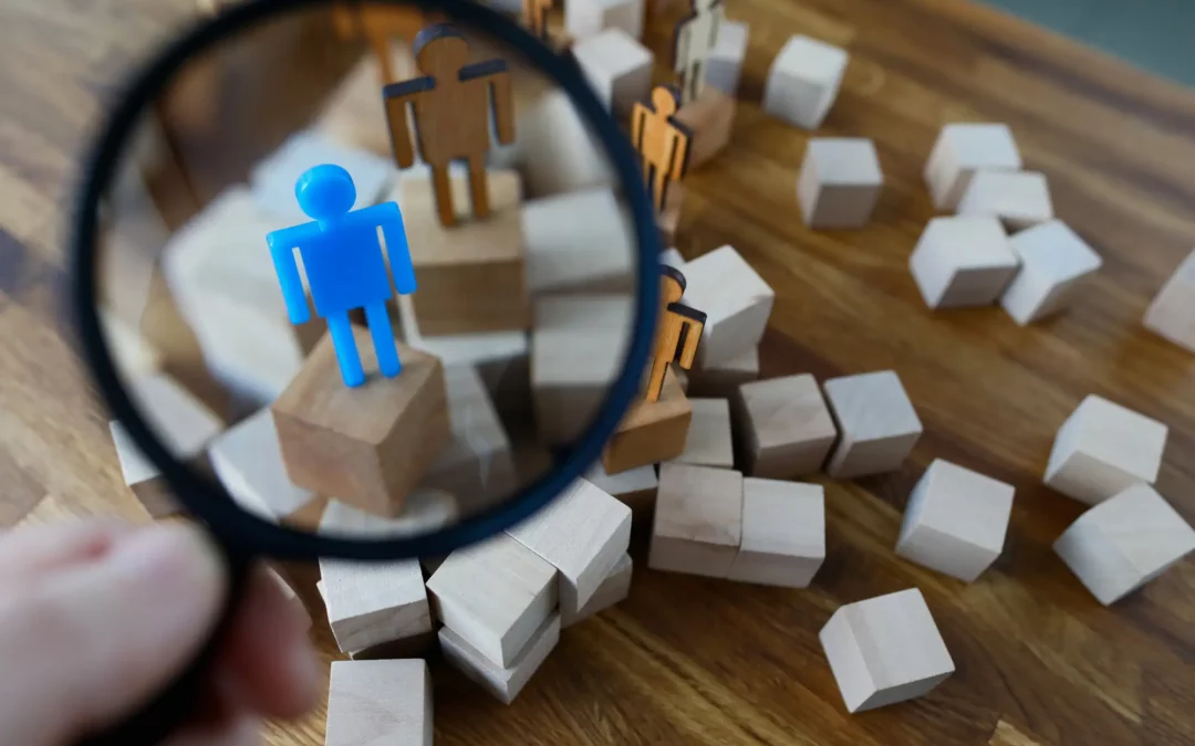 magnifying glass finding a blue figure among other figures