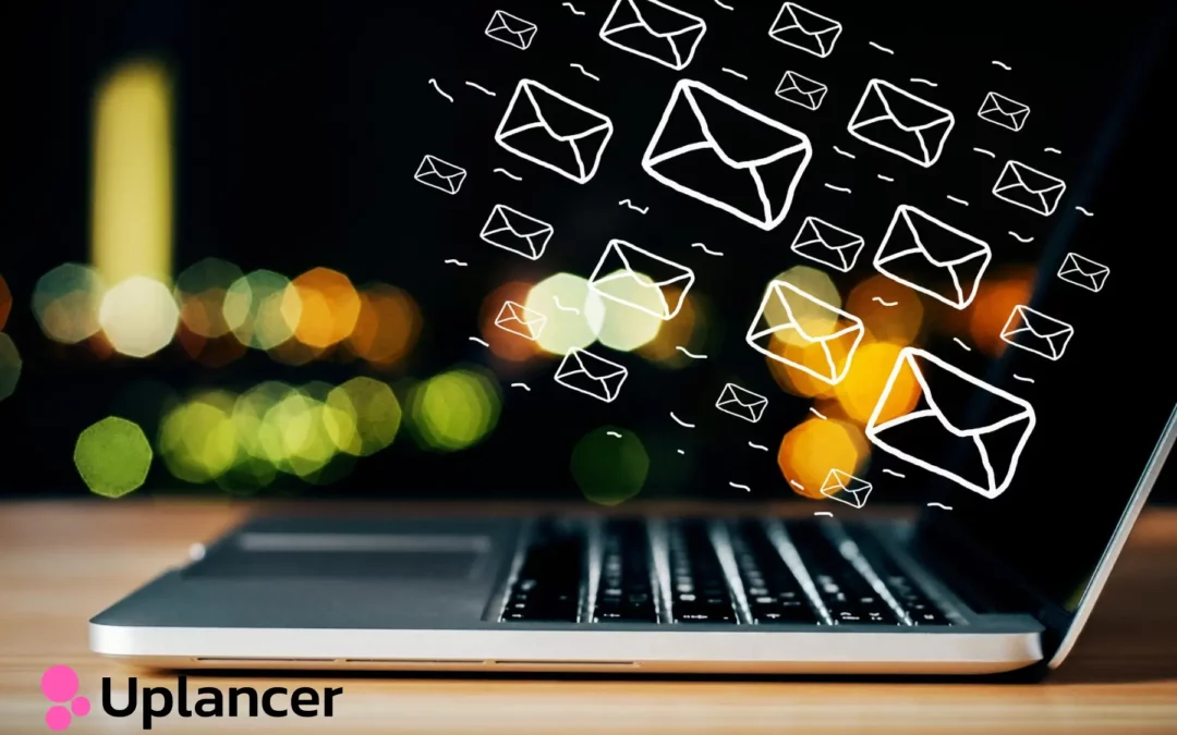 laptop on table with a bunch of emails floating above it