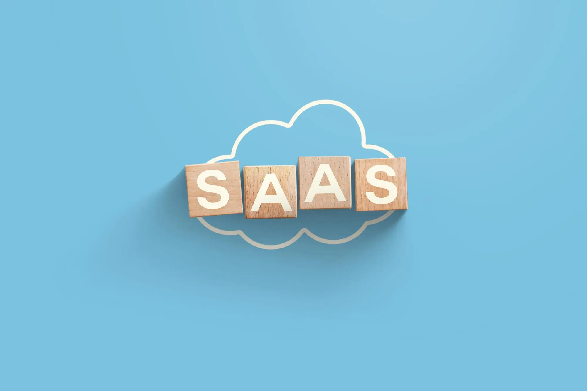 blocks spelling out saas laying on top of an outline of a cloud
